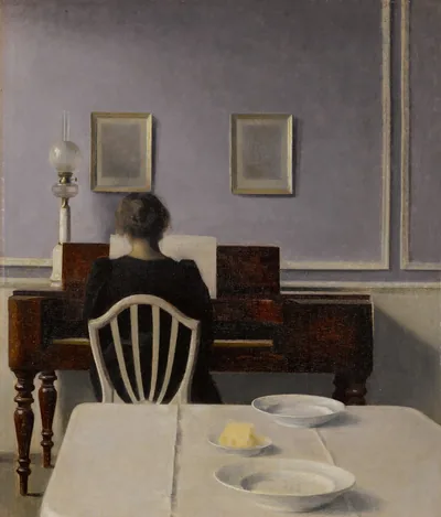 Painting of a woman seen from behind playing an upright piano in a lavender-grey room, a table with two white plates in the foreground.