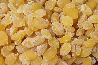 A close-up of dried sea buckthorn fruit, pale golden and flattened.