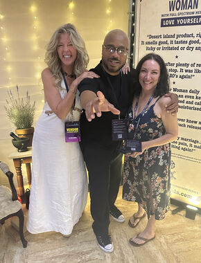 Heather Reilly Hiemstra poses with two fellow attendees in front of the Rockstar Woman banner at the Rockstar Blends booth at Cannadelic Night Market.